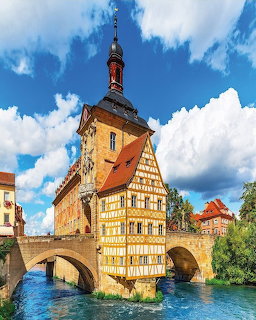 Historic timber-framed town hall on bridge over river in Bamberg, Germany with blue sky