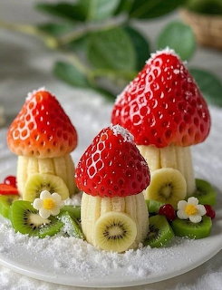 Strawberries placed on banana slices to look like mushrooms, arranged on kiwi with flowers