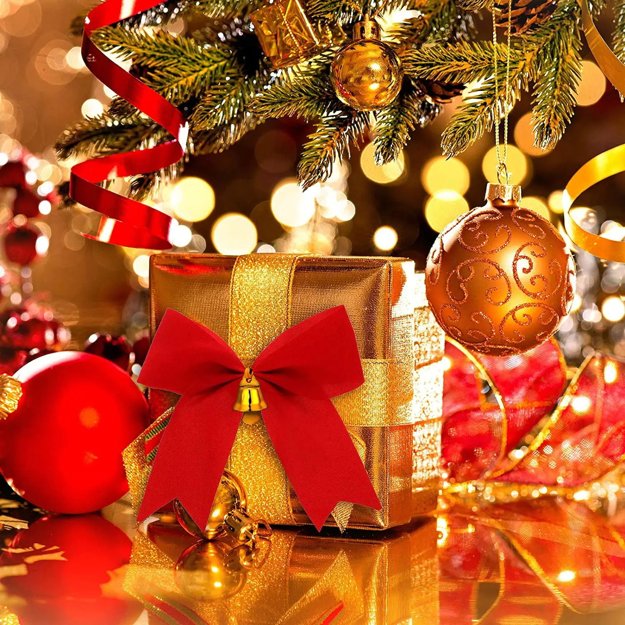 Red and gold wrapped gift under decorated Christmas tree with ornaments and bokeh lights