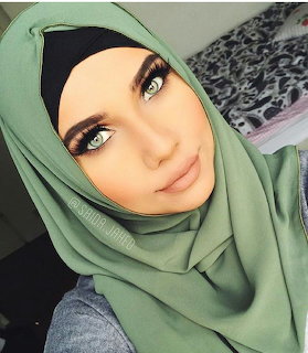 Portrait of woman wearing green hijab with green eyes looking at camera