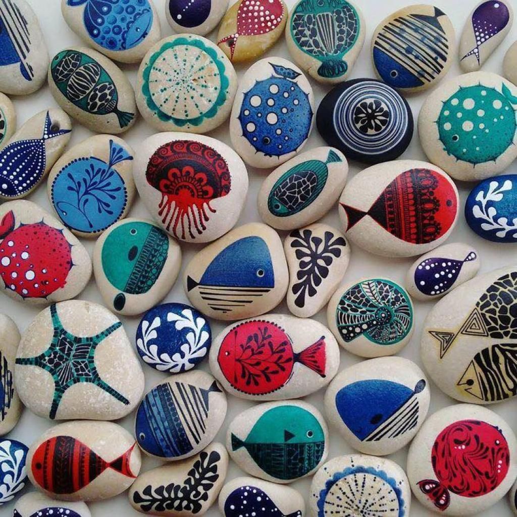 Colorful painted seashells with decorative patterns arranged in a close flat lay