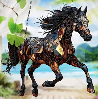 Stained glass black horse with flowing mane hanging against blurred outdoor background
