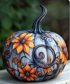 Blue painted pumpkin with orange flowers and decorative swirls on wooden surface