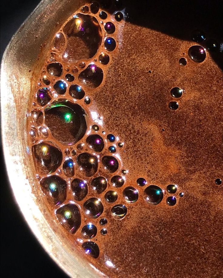 Close-up of bubbly coffee with frothy foam on a brown surface