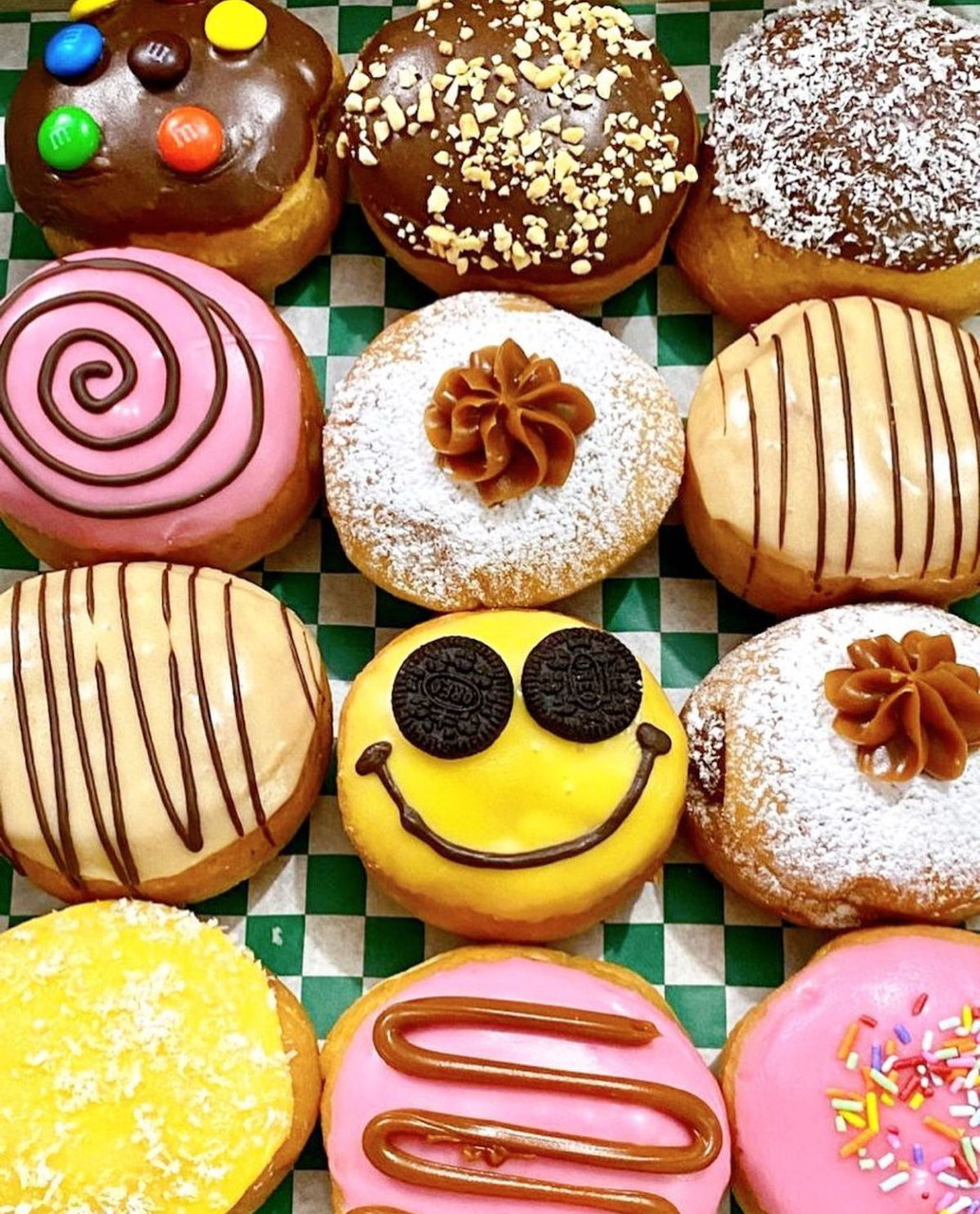 Assorted decorated donuts with colorful toppings on checkered background