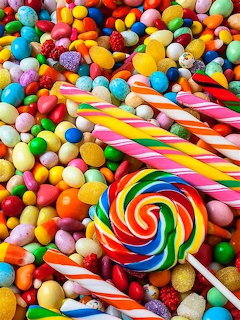 Overhead view of assorted colorful candies including lollipops, jelly beans, and candy canes