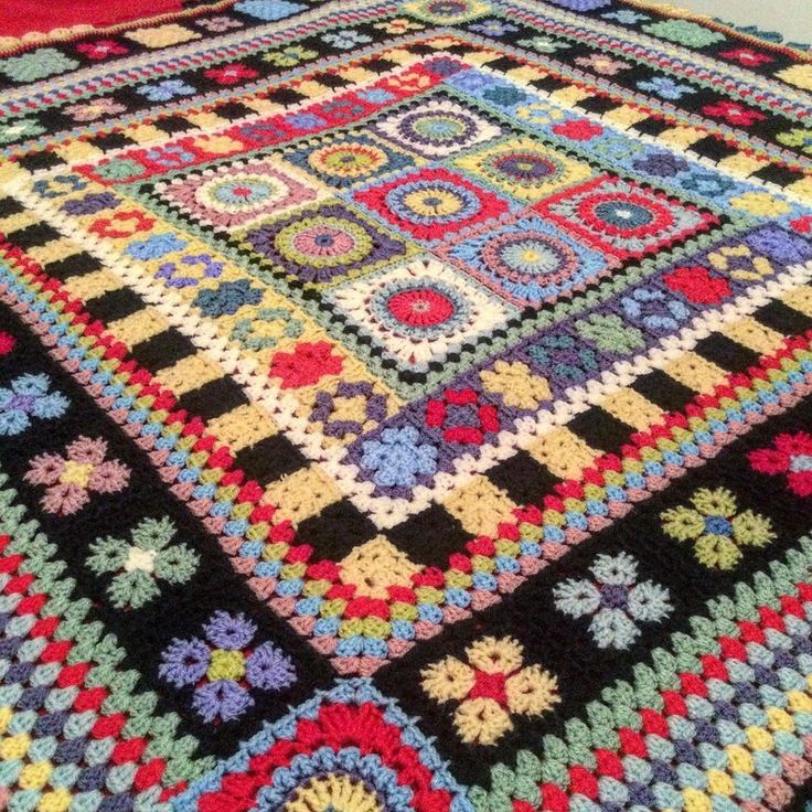 Colorful granny square crochet blanket with multicolored patterns on black background
